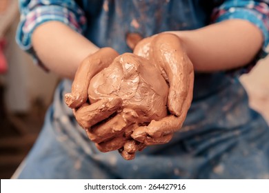 Clay ball. Close-up of female hands holding a ball made of clay to start working on the wheel - Powered by Shutterstock