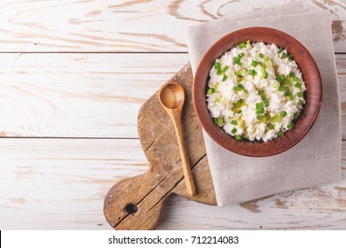 Clay Bowl Of Goat Cream Cheese With Green Onions And Olive Oil, Dip Sauce On Wooden Table, Top View