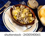 Clay bowl with tasty Valtellinese pizzoccheri - typical Italian pasta from Valtellina with Savoy cabbage, potatoes and cheese