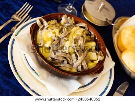 Clay bowl with tasty Valtellinese pizzoccheri - typical Italian pasta from Valtellina with Savoy cabbage, potatoes and cheese
