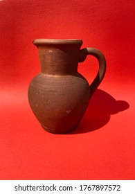 Clay brown vintage jug on a red background
