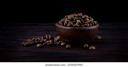 Clay cup full of roasted coffee beans and coffee beans scattered next to it on a wooden surface. - Powered by Shutterstock