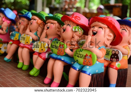 Clay Doll lovely and smiling happily for decorated (Quote Thai language on 
label mean Happy and Lucky)