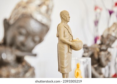Clay figure of a Buddhist monk holding a pot with coins, For good luck in a business starting.