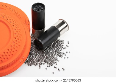 Clay Flying Target And Shotgun Shell Ammunition With Lead Pellets On White Background , Gun And Shooting Game