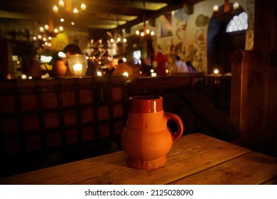 Clay jug with beer on a wooden table in a medieval tavern - Shutterstock ID 2125028090