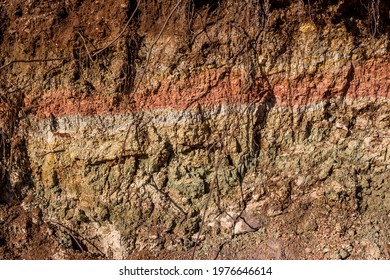 Clay layer folded in layers of different colors dried in the sun - Shutterstock ID 1976646614