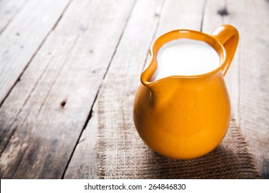 Clay Milk Jug Isolated On Wooden Background