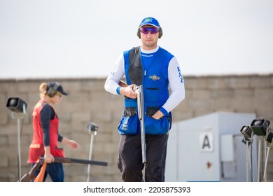 Clay Pigeon Shooting. An Athlete Shoots A Gun At Moving Targets, Sport Gun Shooting, Clay Pigeon Shooting. Training Process At The Shooting Range. Cyprus, Larnaca - August 20, 2022