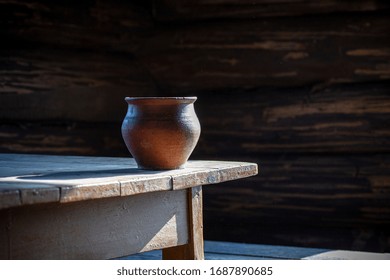 Clay pot (clay pottery) on an old wooden table in an old rustic house. Pottery and peasant life. Still life with pottery. - Powered by Shutterstock