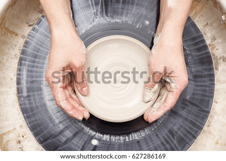 Similar – Young female sitting by table and making clay or ceramic mug