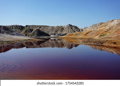 Clay quarry, clay mining. Lifeless landscape. Colored Lake in the quarry.                