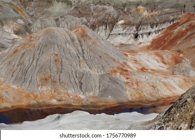  Clay quarry, clay mining. Lifeless landscape. Mountains of clay with red spots.                              