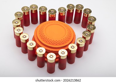 Clay shooting target and shotgun shell in the shape of a heart on white background , Shotgun game lover