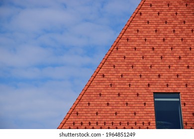 Clay Tile Roof. Steep Slope In Red Brown Color. Bright Blue Sky Wand White Clouds. Roof Window Or Skylight. Metal Ice And Snow Guard In Square Pattern. Modern New Construction Concept. Snow Breaker