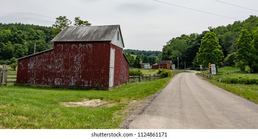 Claysville, Pennsylvania/USA- June 8, 2018:  Faded Red Barn On A Country Road In Rural Appalachia.