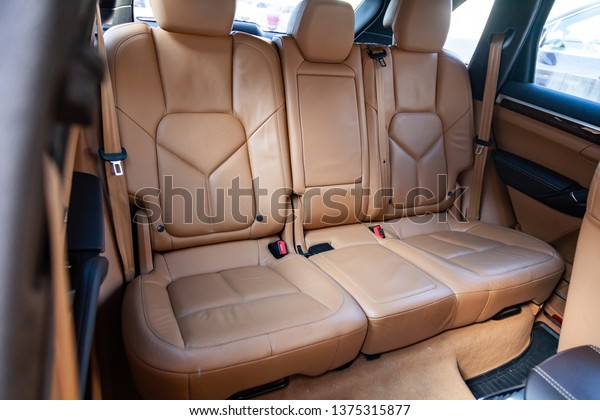 Clean after washing
the rear passenger seats of matte brown or beige genuine leather
inside the interior of an expensive luxury suv, preparation before
selling the car.