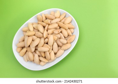 Clean Almonds On Small White Dish On Green Paper