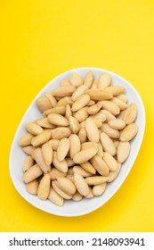 Clean Almonds On Small White Dish On Yellow Paper