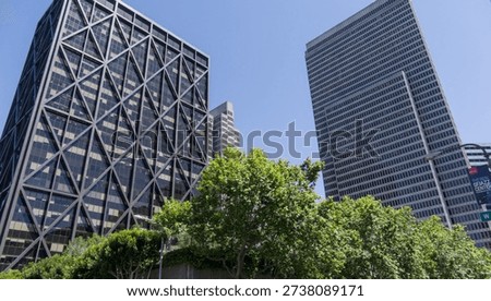 A clean architectural composition featuring modern buildings framed by soft greenery. The scene highlights San Francisco’s contemporary urban design and the contrast between structured lines and natural elements.
