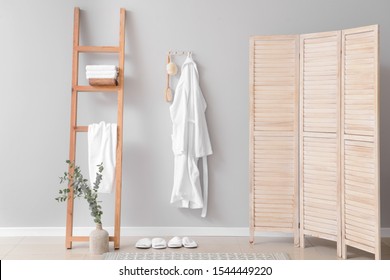 Clean bathrobe hanging on wall in room