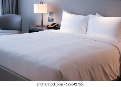 Clean Bedding Sheets And Pillow On Natural Wall Room Background. White Bedding And Pillow In Hotel Room. White Pillows On Empty Bed.