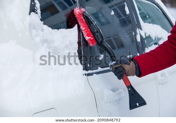 clean car of\
snow after blizzard winter\
season