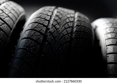 Clean car tyres spinning against dark background closeup