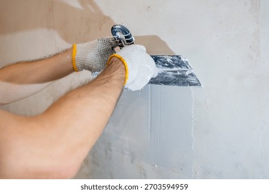 A clean, close-up view of the process: applying a final skim coat of plaster with precision to an interior residential wall.