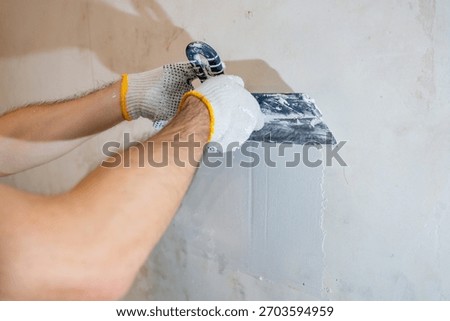 A clean, close-up view of the process: applying a final skim coat of plaster with precision to an interior residential wall.
