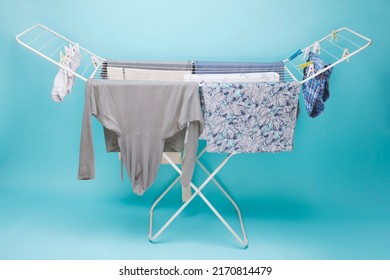 Clean Clothes After Washing Weigh On The Clothes Dryer Against On Blue Background.