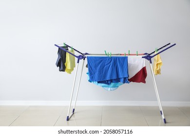 Clean clothes hanging on dryer indoors