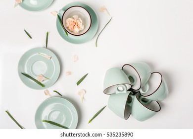 Clean Dishes, Coffee Or Tea Set. Composition Of Elegant Porcelain Cups And Saucers With Flower Petals And Copy Space At White Background, High Key, Top View And Flat Lay.