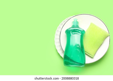 Clean dishes and detergent on color background