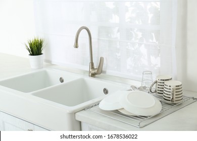 Clean dishes drying on rack in modern kitchen - Shutterstock ID 1678536022