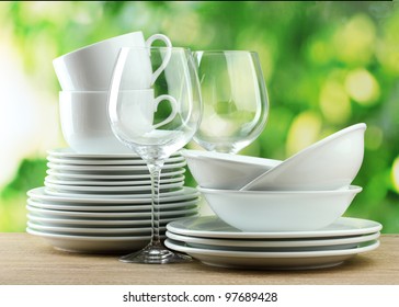 Clean Dishes On Wooden Table On Green Background