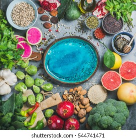 Clean Eating Concept Over Grey Background With Bright Blue Plate In Center, Top View, Copy Space. Vegetables, Fruit, Seeds, Cereals, Beans, Spices, Superfoods, Herbs For Vegan, Gluten Free Diet