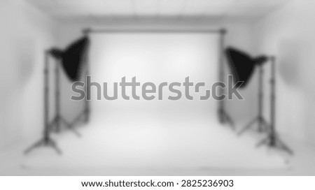 A clean, empty photography studio setup with a white backdrop and professional lighting equipment ready for a shoot.