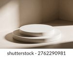 A clean, empty stage featuring two tiered circular platforms bathed in soft, diffused light and subtle shadows, perfect for product display