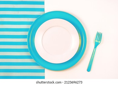 Clean Empty White Plate And Fork On Striped Blue White Napkin Background , Top View, Copy Space.