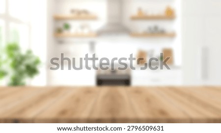 A clean empty wooden table surface with a bright out of focus kitchen interior background
