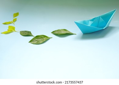 Clean Energy For Sea And Cargo Transportation And Travel And Sustainable Maritime Transport Concept. Paper Boat Emitting Fresh Green Leaves. 