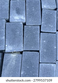 Clean flat lay texture of grey concrete paving stones in a patte