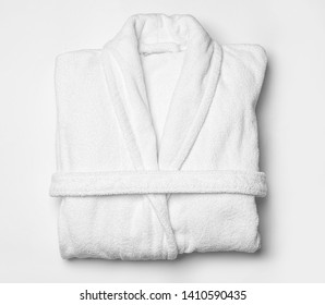 Clean folded bathrobe on white background, top view