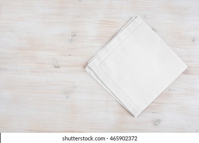 Clean folded linen napking on wooden texture background with copyspace