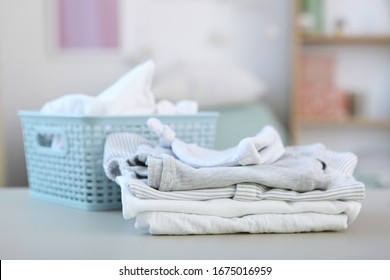 Clean And Fresh Baby Clothes Stacked On A Table. Washing Baby Clothes.
