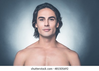 Clean And Fresh. Portrait Of Young Shirtless Man Looking At Camera While Standing Against Grey Background 