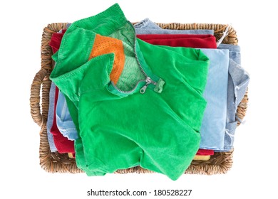 Clean Fresh Washed Summer Clothes In A Basket Neatly Folded And Viewed From Above With A Colorful Green Shirt On Top Of The Pile, Overhead Close Up View Isolated On White