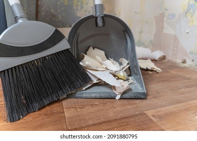 Clean Up Garbage After Repairs.Sweep Up Construction Debris With A Brush In A Dustpan.Sweeping At Home.Tools For Cleaning The House.Make Home Repairs.The Dust.Wall Repair.Torn Wallpaper From The Wall