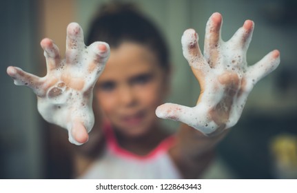 Clean hands half the health. Hands of a little girl of foam. Close up. Copy space. Focus is on hands.